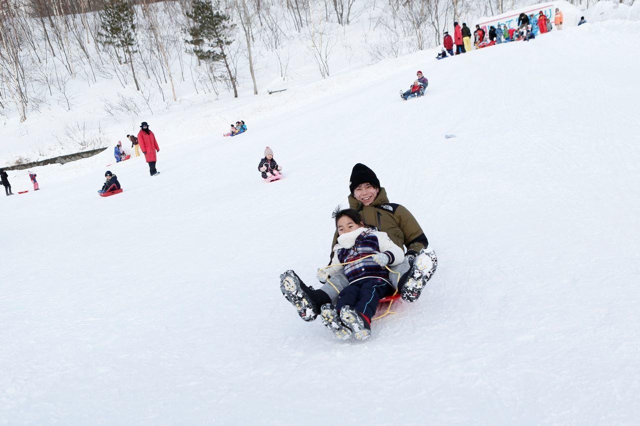 雪の滑り台をソリに乗ってすべり下りよう!の写真