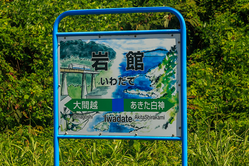 Train station name signs with scenery illustration in Iwadate Station