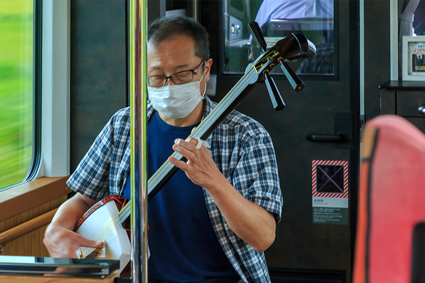 Tsugaru-shamisen performer shows passionate skills in the running train.