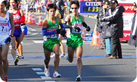3区原田選手から4区藤原選手へ襷をつなぐ